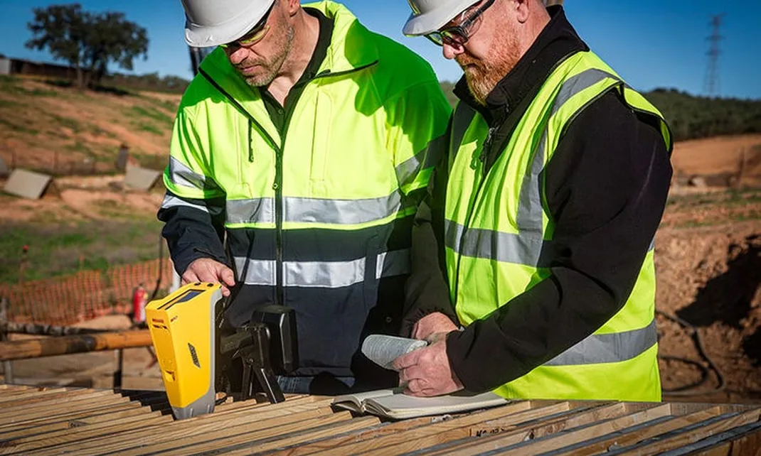 Geologists analyzing core samples with a handheld XRF analyzer