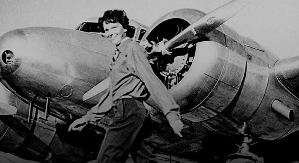 Amelia Earhart standing beside her aircraft
